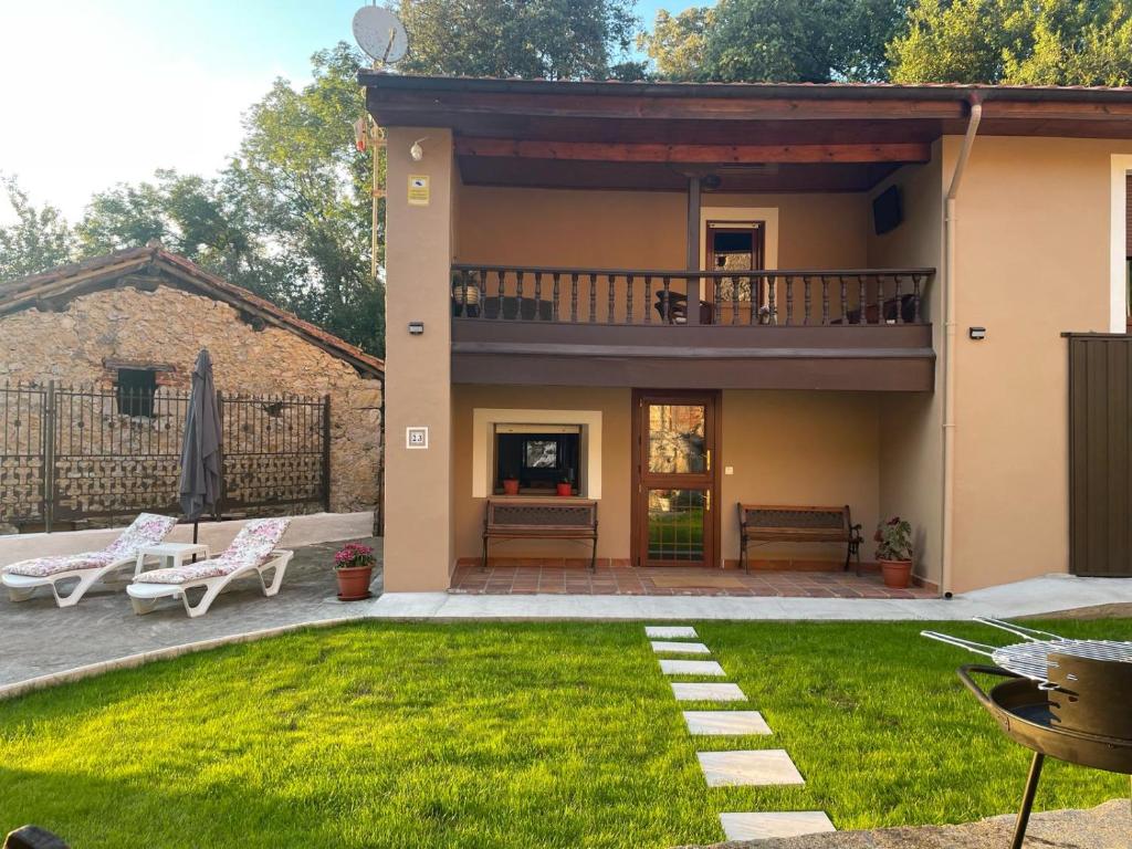 een huis met een balkon en een tuin bij Casa Mariyina in Ribadesella