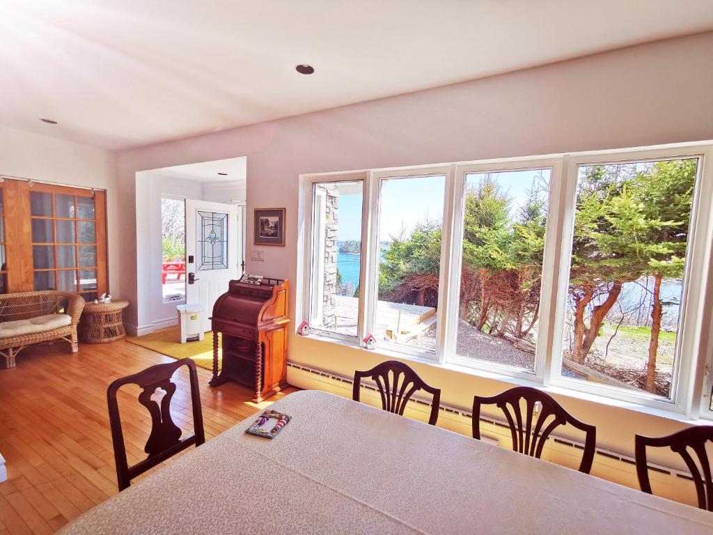 a dining room with a table and chairs and windows at 181 Oceanside Inn in Peggy's Cove