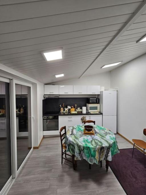 une cuisine avec une table et des chaises dans une pièce dans l'établissement Maison a 10 minutes de Paris SLZ, à Colombes