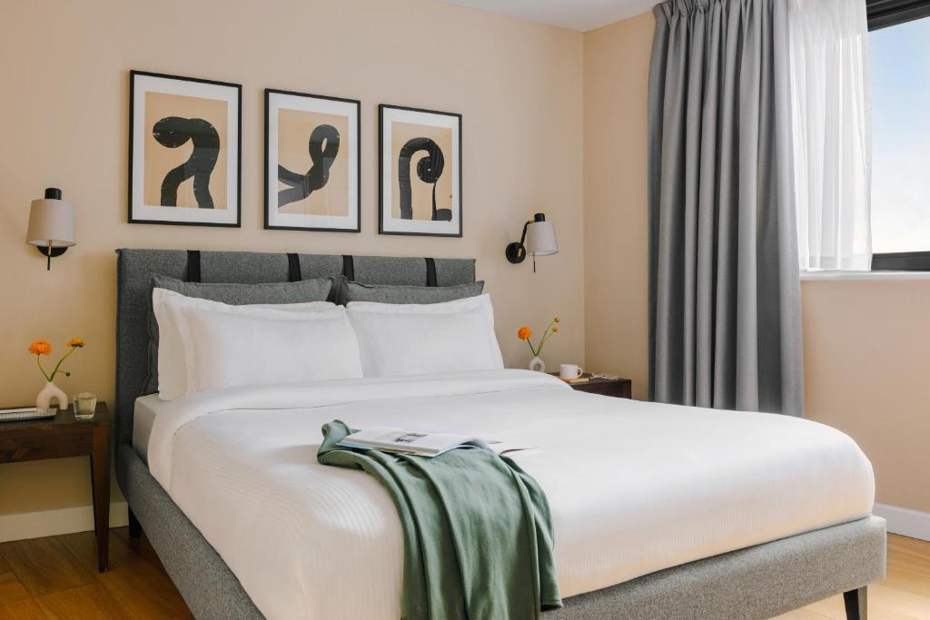 ロンドンにあるサコ フィッツロビアのベッドルーム1室(壁に3枚の写真が飾られた白い大型ベッド1台付)