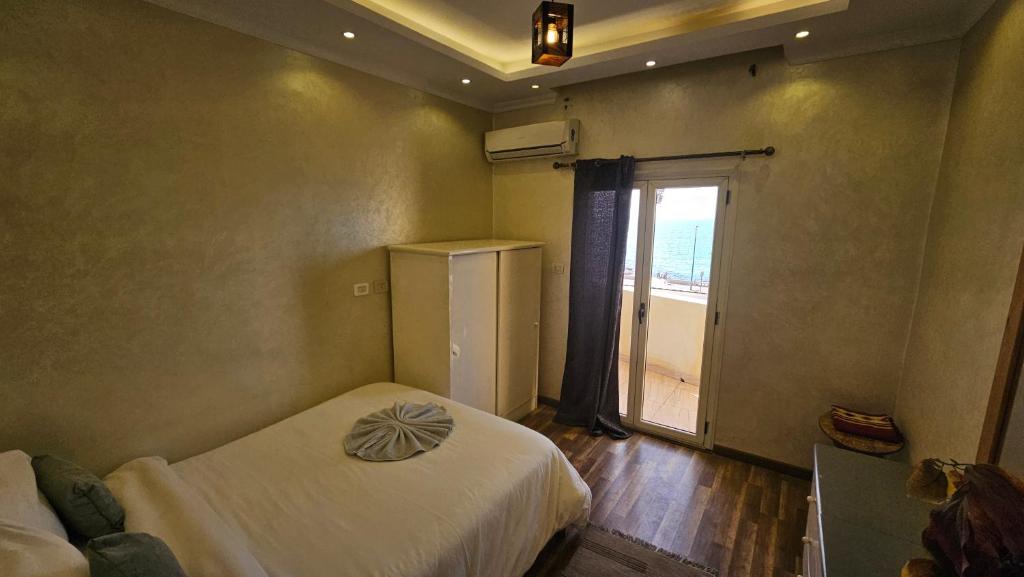 Habitación pequeña con 2 camas y ventana en Simple sea view apartment - families only, en Alejandría
