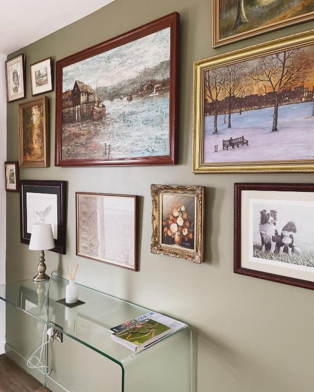 a room with a glass table and paintings on the wall at Ty Ray Penmaes in Rhayader