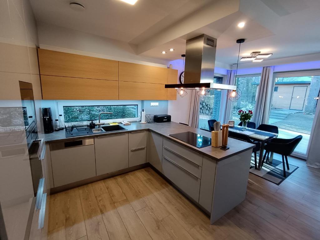 une cuisine avec des placards blancs et une salle à manger dans l'établissement Peace of mind cottage, à Tata