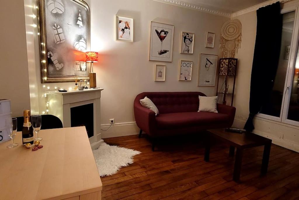 - un salon avec un canapé rouge et une cheminée dans l'établissement Appartement Cosy 2 personnes, à Levallois-Perret
