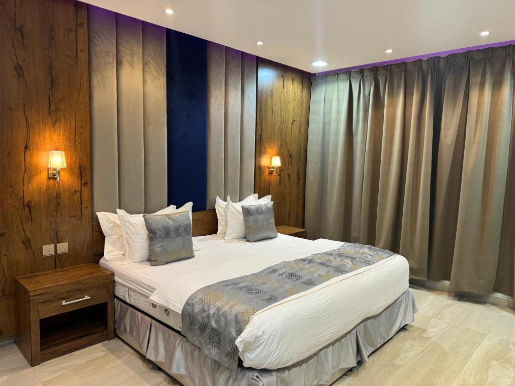 a bedroom with a large bed with two pillows at الاتحاد الذهبية للشقق المخدومة 1 in Al Hofuf