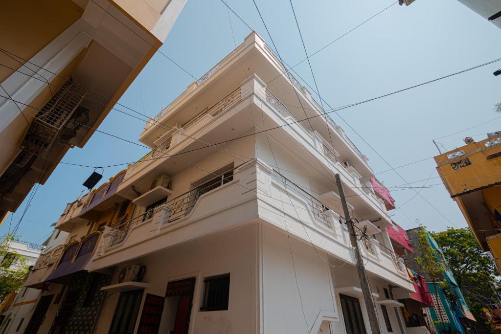 biały budynek z balkonem przy ulicy w obiekcie Maison Annai w mieście Puducherry