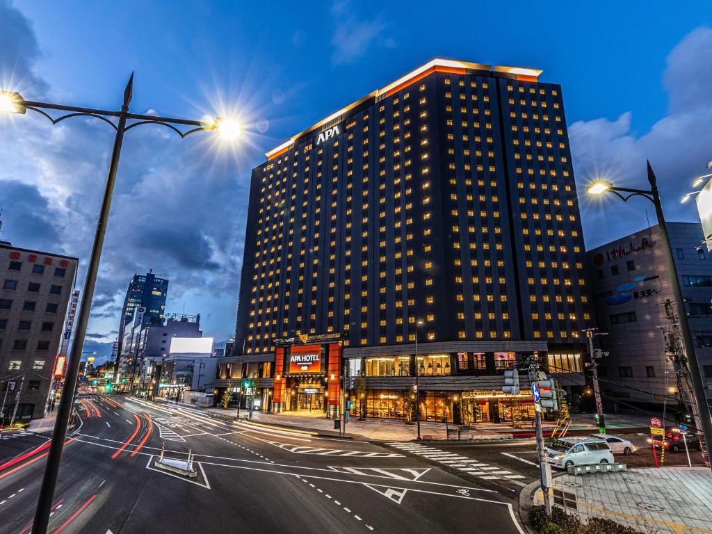 un edificio alto en una calle de la ciudad por la noche en APA Hotel & Resort Niigata Ekimae Odori en Niigata