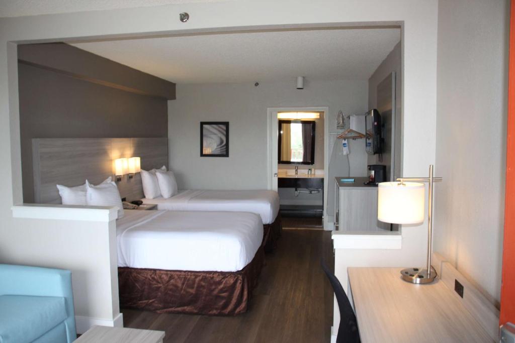 Habitación de hotel con 2 camas y escritorio en Boca Suites Deerfield Beach; SureStay Collection by BW, en Deerfield Beach