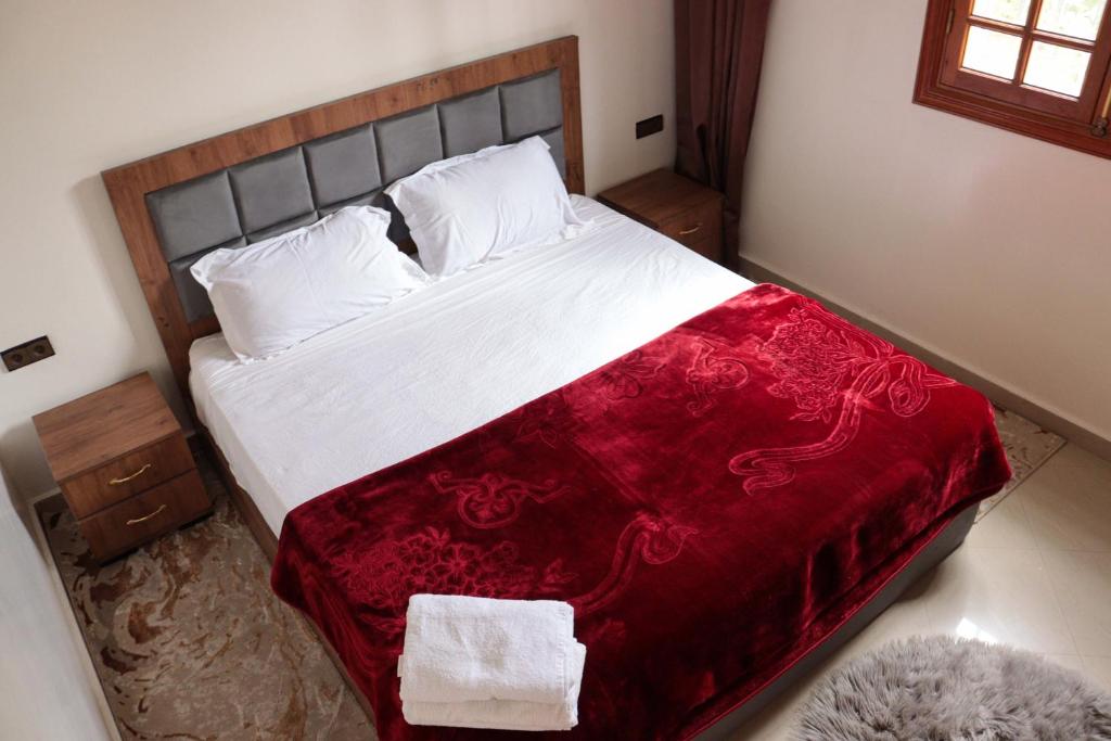 1 dormitorio con 1 cama grande con manta roja en Royal mirage villa(families only), en Marrakech