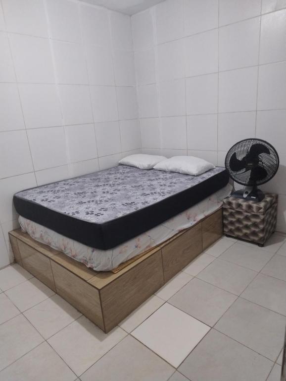 uma cama sentada numa moldura de madeira num quarto em Casa Duplex na Praia de Catuama em Ponta do Funil