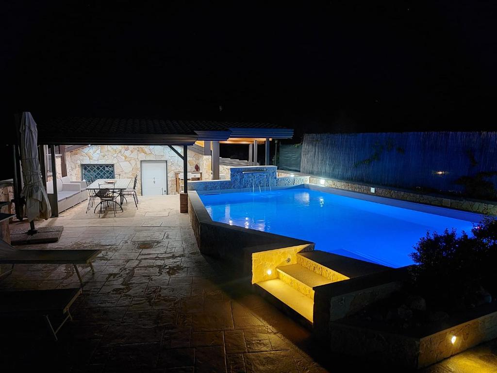 a large swimming pool at night with a table at Blu Etna Casa Vacanze in Zafferana Etnea