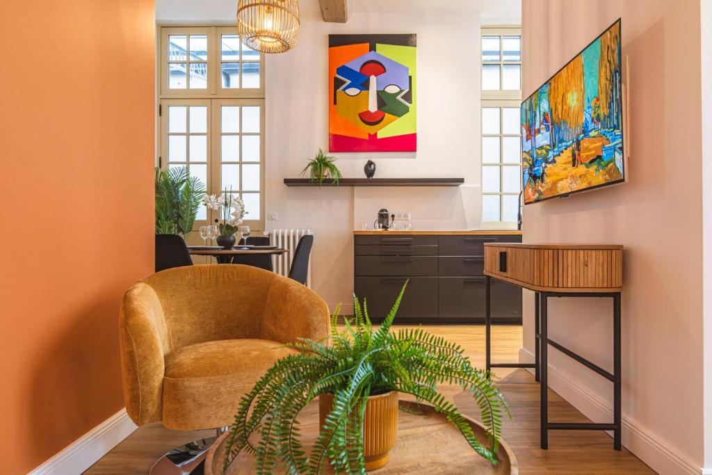un salon avec une chaise et une table dans l'établissement MM Suites Loft Cathédrale, à Reims