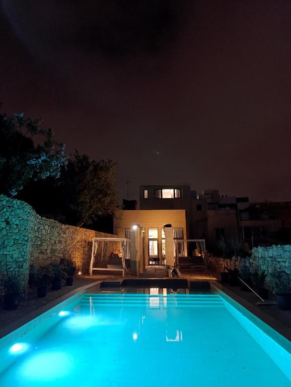 - une piscine la nuit avec une maison en arrière-plan dans l'établissement Villa Vera with private pool near Valletta, à Tal-Pietà