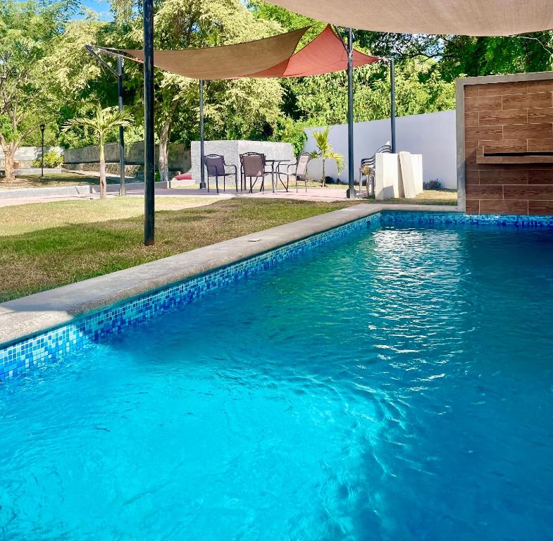 una piscina de agua azul y una sombrilla en EXCELENTE CASA RESIDENCIAL PRIVADO- ALBERCA-SEGURIDAD 24-7-ac, en Ciudad Valles