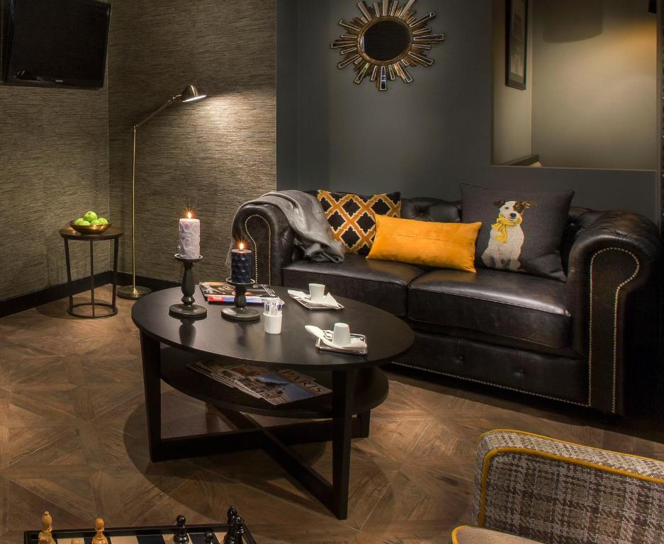 a living room with a leather couch and a table at Hôtel International Paris in Paris