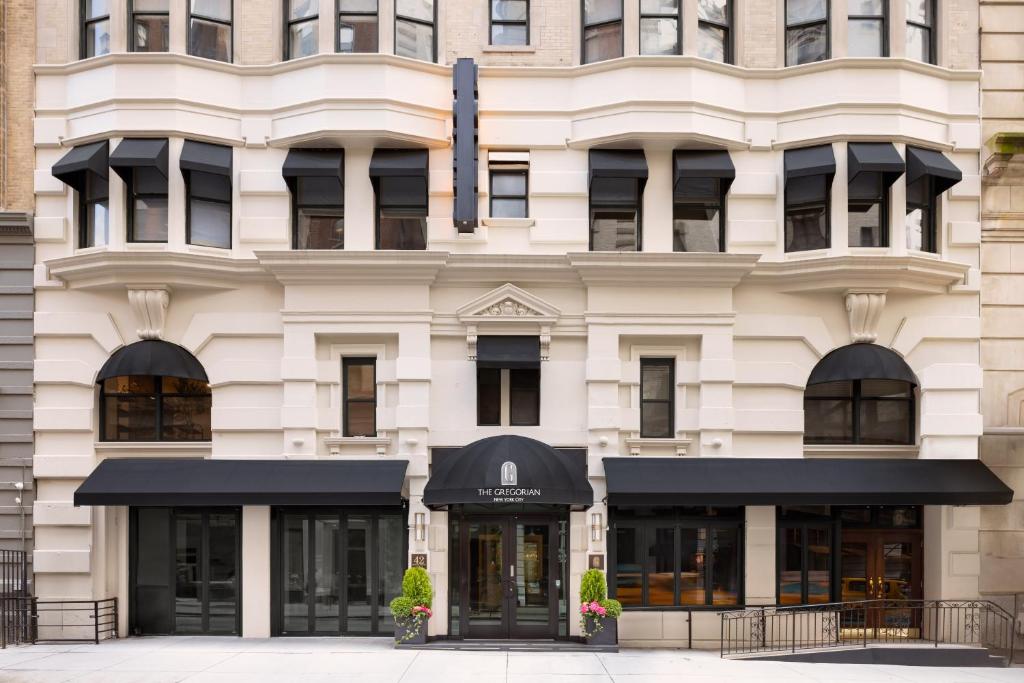 a building with black awnings in front of it at The Gregorian New York City in New York