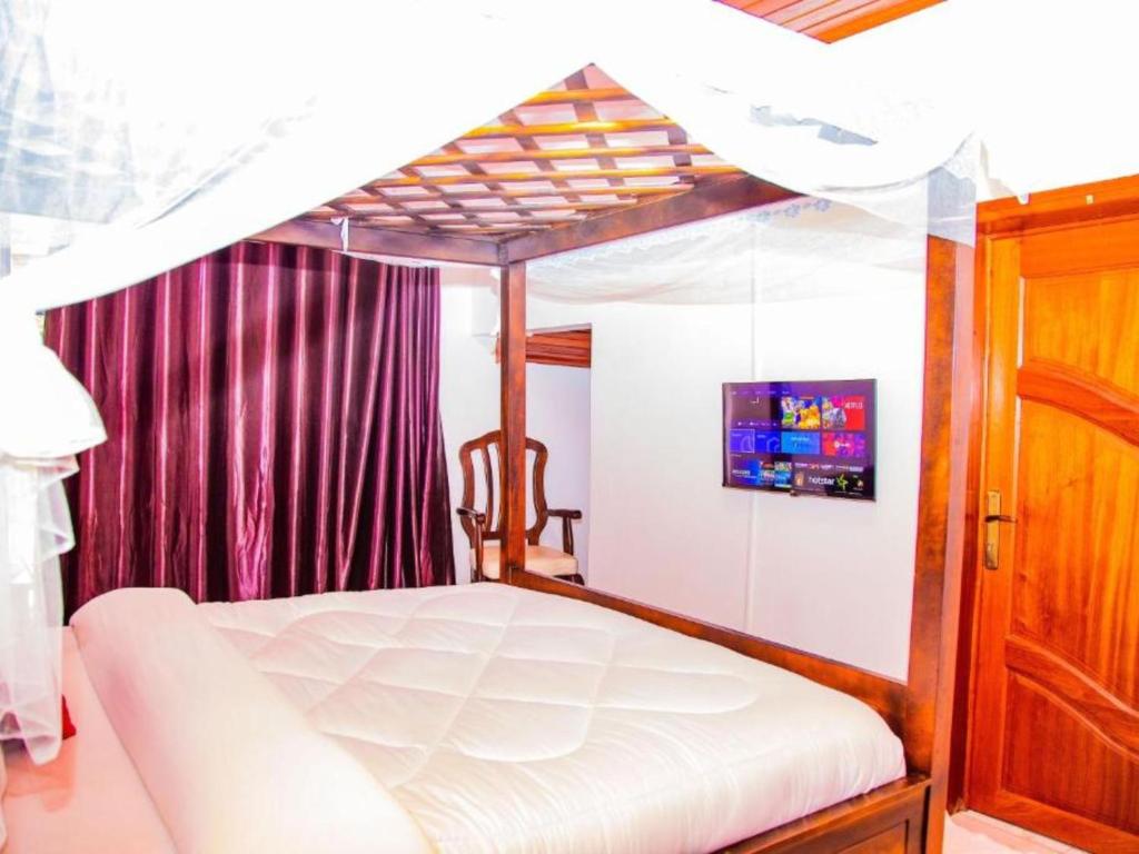 ein Schlafzimmer mit einem Himmelbett in einem Zimmer in der Unterkunft Kigali's first stay in Kigali