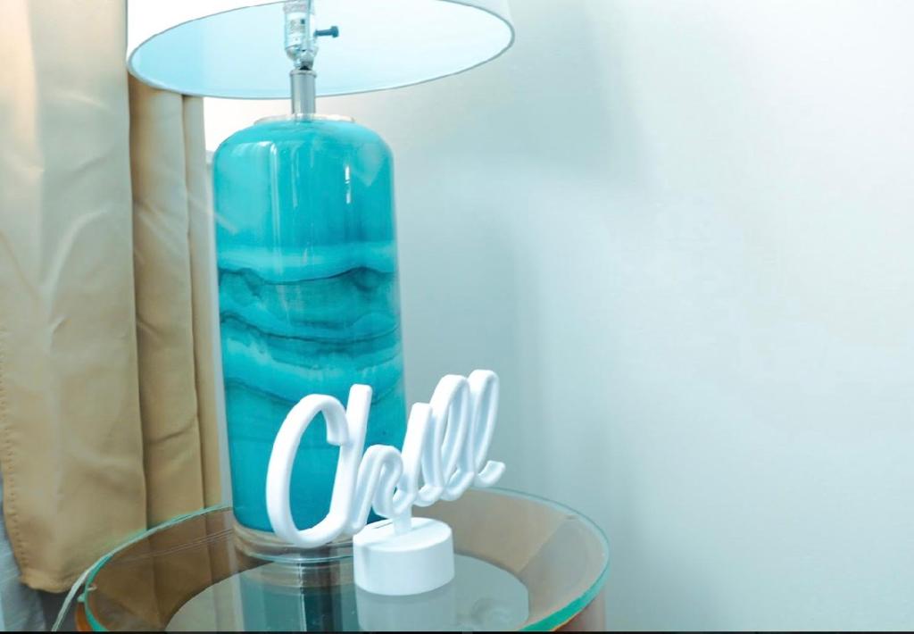 a glass table with a lamp and a bottle on it at Chic 4 bedroom Getaway in Atlantic City! in Atlantic City