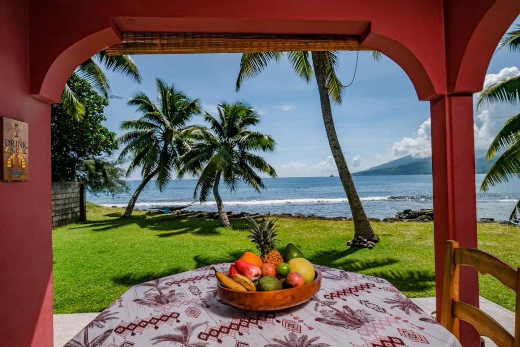 a bowl of fruit on a table with a view of the ocean at Bungalow Moana in Taravao