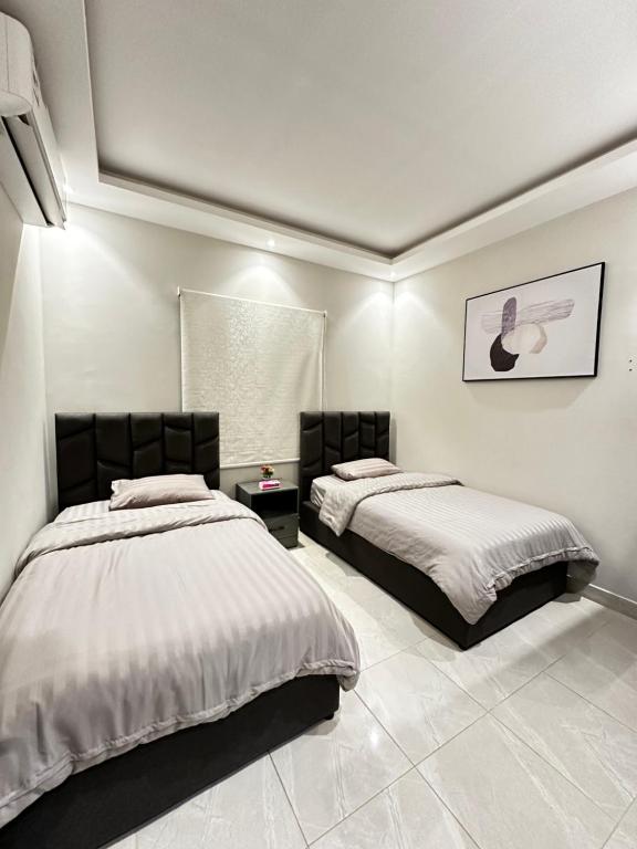 um quarto com 2 camas e uma janela em هابي رومز em Al Khobar