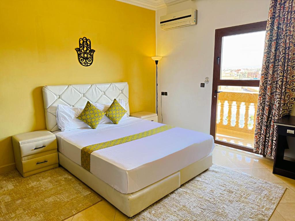 Un dormitorio con una gran cama blanca y una ventana en Residence Chay - Luxury Appart, en Ouarzazate