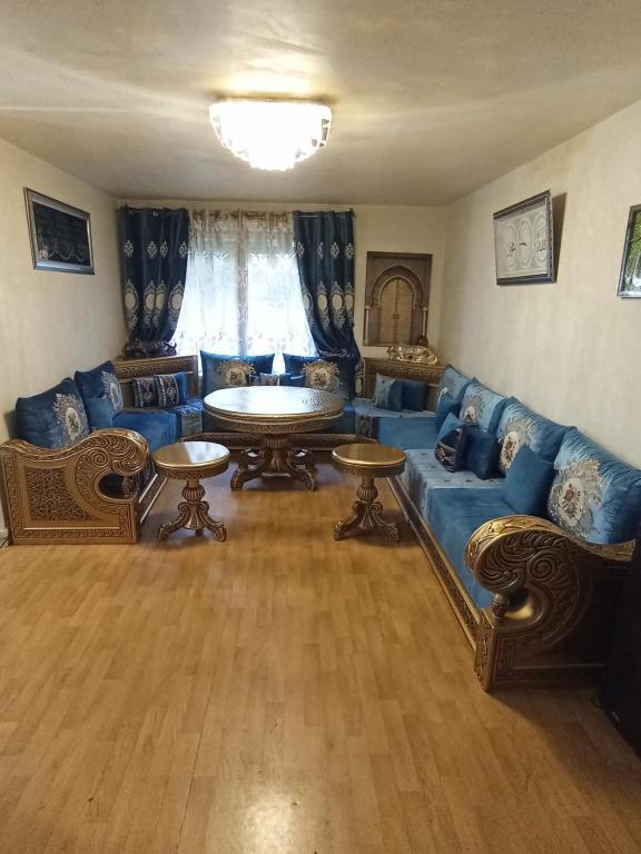 un salon avec des canapés bleus et une table dans l'établissement Grand appartement Paris 11ème, à Paris