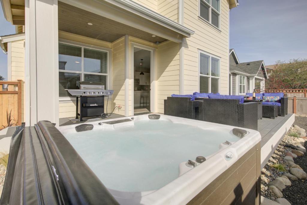 a hot tub on the patio of a house at The Sand's Ours, Just Say When in Ocean Shores