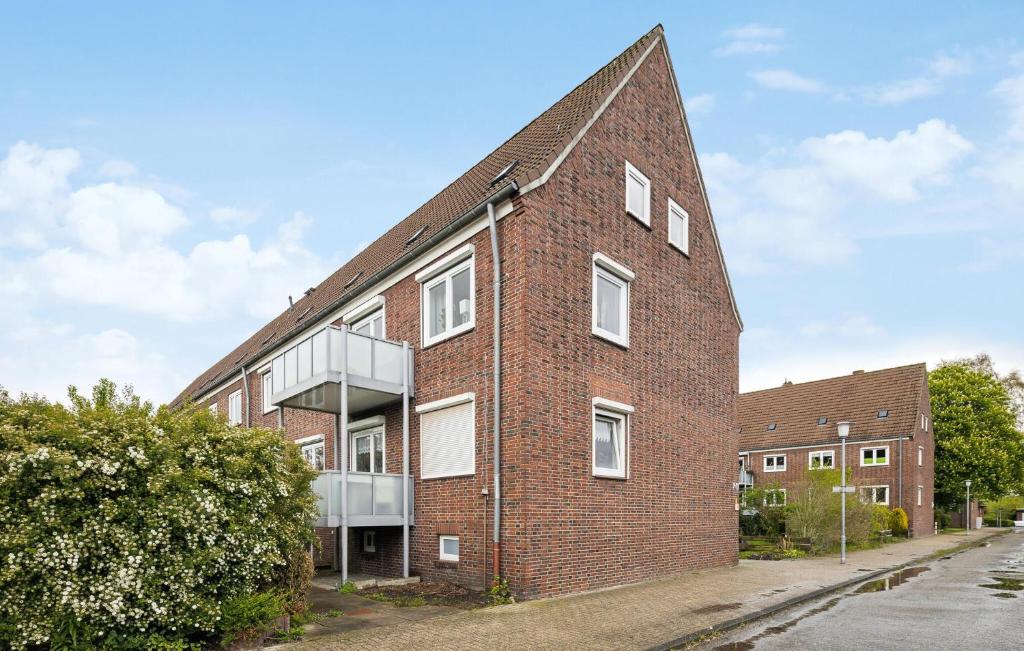 a brick building with a glass balcony on a street at Küstenkind in Wilhelmshaven