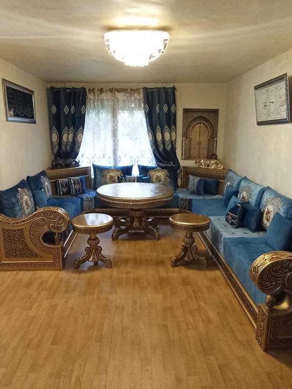 un salon avec un canapé bleu et une table dans l'établissement Grand appartement Paris 11ème, à Paris