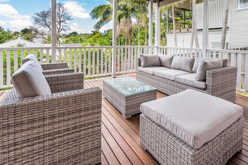 - une terrasse couverte avec des canapés en osier et une table dans l'établissement Elegant 4-Bedroom Residence with Entertaining Area, à Brisbane
