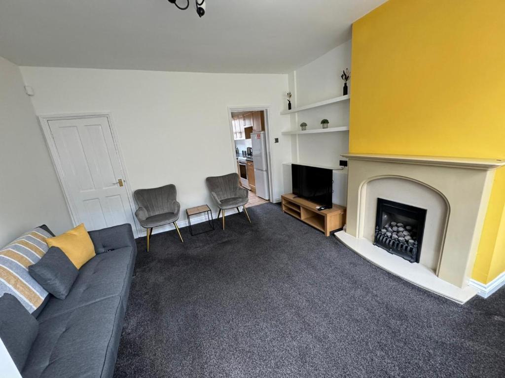 a living room with a couch and a fireplace at Cumberland House-2 Bed House in Workington