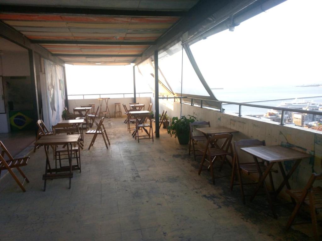 - une rangée de tables et de chaises dans une chambre avec fenêtres dans l'établissement Histórico Hotel, à Salvador
