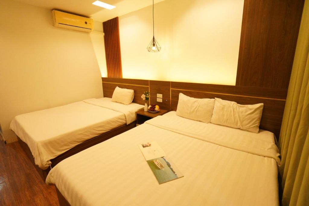 duas camas num quarto de hotel com uma bandeja em cima em Hanoi Rose Flower Hotel & Spa em Hanói