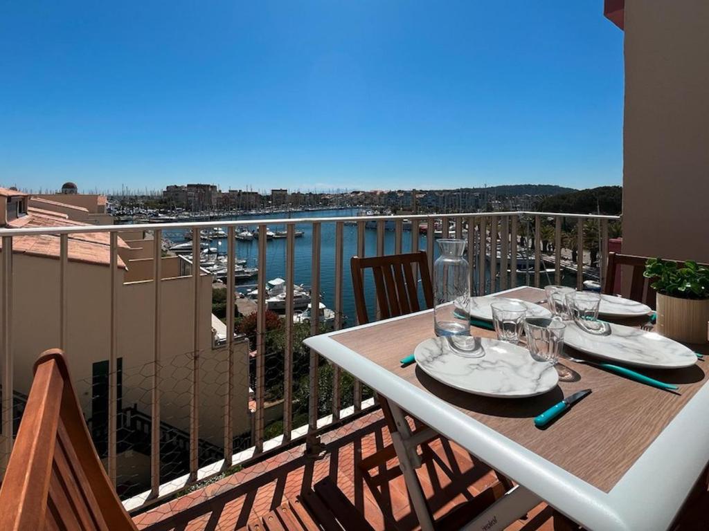 une table sur un balcon avec vue sur l'eau dans l'établissement Appartement avec parking à Gruissan, 4 couchages, proche plage - FR-1-229-886, à Gruissan
