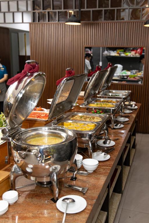 A close view of covered hot-food dishes lines a breakfast buffet counter.