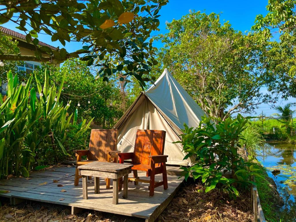 a tent with chairs and a table on a wooden deck at Binifarm Tropical Retreat in Cu Chi