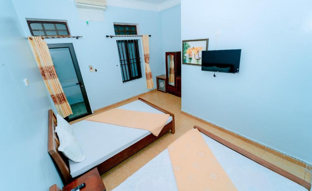 een kamer met een bed en een tv. bij Nhà Nghỉ Duy Tân in Sầm Sơn