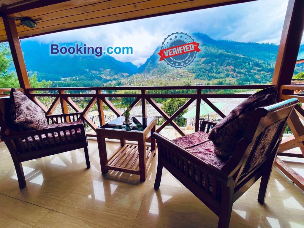 a room with two chairs and a balcony with a view at The Four Season Hotel & Resort, Manali in Manāli