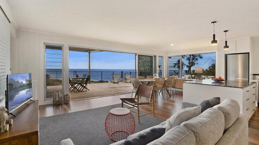 a living room with a view of the ocean at 'Surfside' by HolidayCo in Killcare