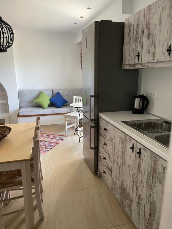 a kitchen with a refrigerator and a table with a dining room at Kostas Studios in Faliraki