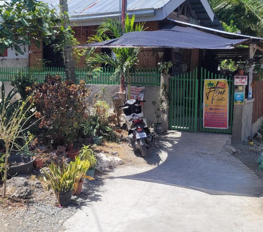 una motocicleta estacionada frente a un edificio con una puerta en Home Sweetie Homestay & Bunkbeds, en Moalboal