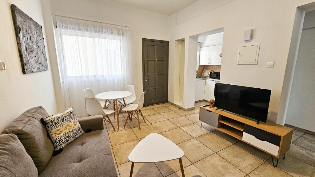 sala de estar con sofá, TV y mesa en FlipFlop City Center Apartment, en Lárnaca