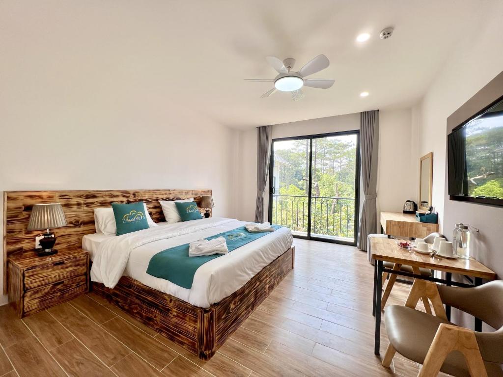 a bedroom with a large bed and a table at Zephyrus Villa - Standard 1 in Kon Von Kla