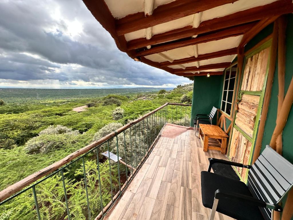 a balcony of a house with a bench and a view at Tree house in Ngong