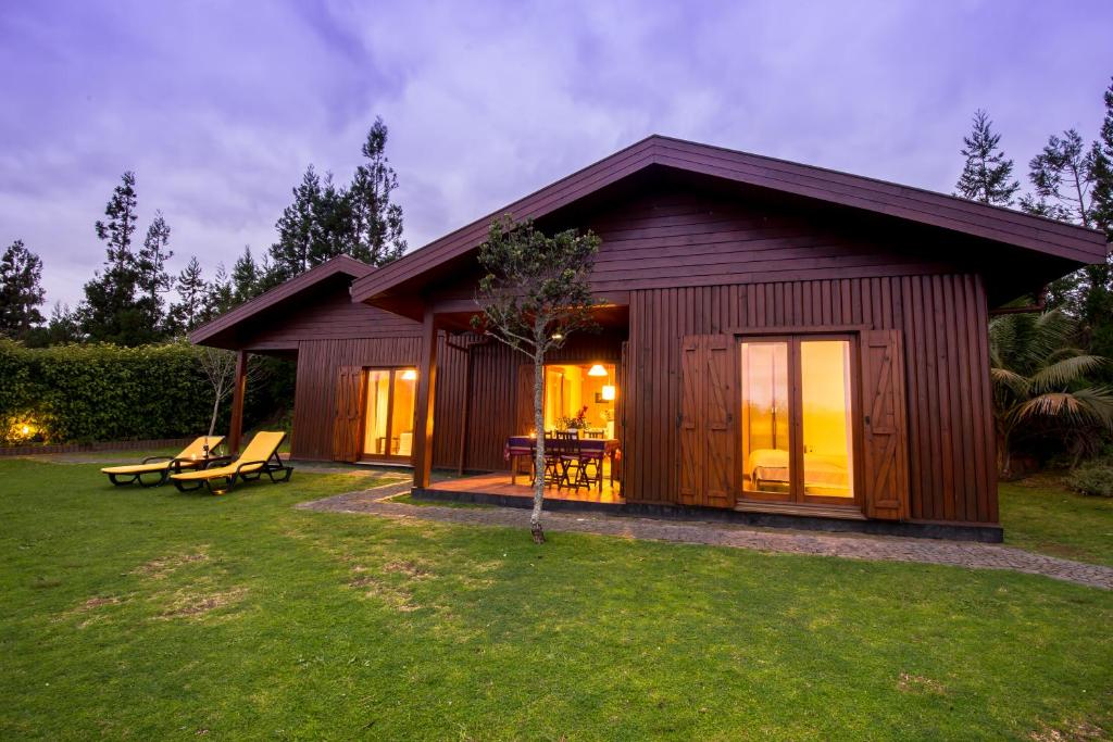 a small cabin with a patio in a yard at Quinta dos Curubas in Vila Franca do Campo