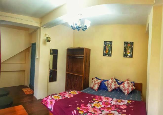 um quarto com uma cama com lençóis e almofadas roxos em Silver Sun Official em Darjeeling
