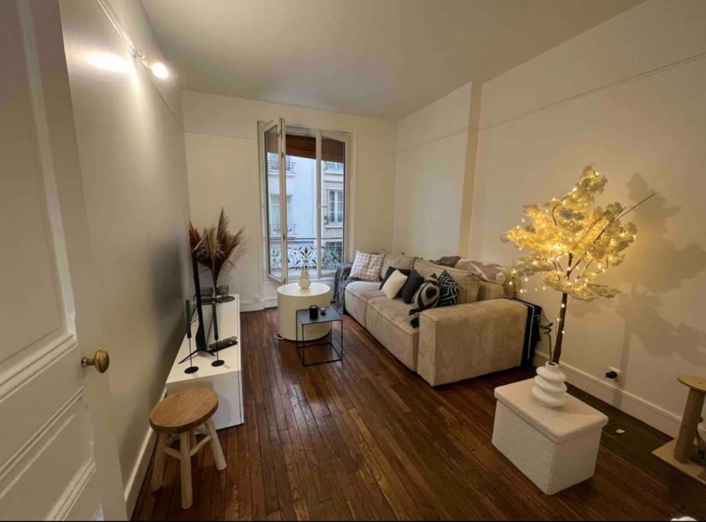 un salon avec un canapé et une table dans l'établissement Cosy Haussmannien appartement, à Paris