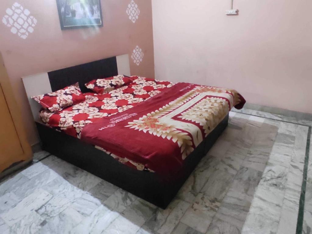 um quarto com uma cama com um edredão vermelho em OYO Hotel AVS 8268 em Moradabad