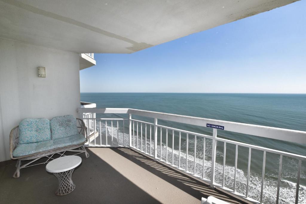 a balcony with a chair and the ocean at 1412 Waters Edge Resort condo in Myrtle Beach
