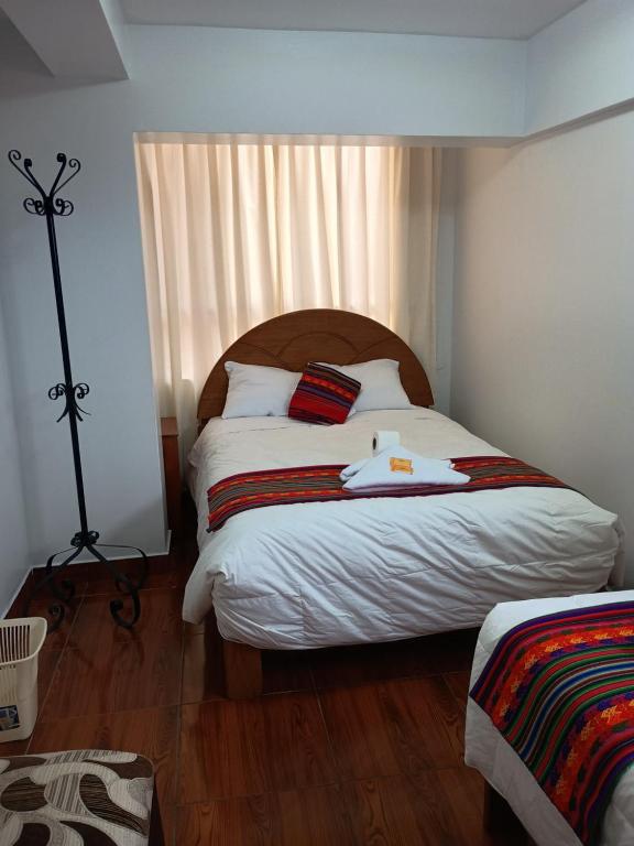 una camera da letto con un letto grande con lenzuola bianche di Hotel TIKA AYNA Cerca a la plaza de Armas CUSCO a Cuzco
